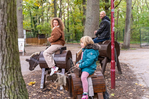 Zwei Kinder reiten auf Holzpferden auf dem Campingplatz von Baltic Freizeit.