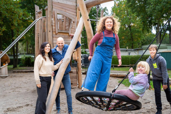 Junge Familie mit Kindern auf dem Spielplatz vom Campingplatz Baltic Freizeit.