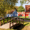 Holzbrücke vor farbenfrohen Hütten im Herbst bei Baltic Freizeit Campingplatz.