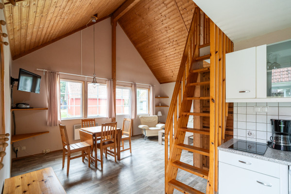 Geräumiges Wohnzimmer mit Holztreppe, Essbereich und Küchenzeile im Campingplatz Baltic Freizeit in Markgrafenheide.