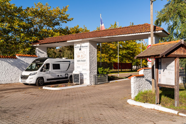 Toreinfahrt auf dem Campingplatz von Baltic Freizeit mit ausfahrendem Wohnmobil..