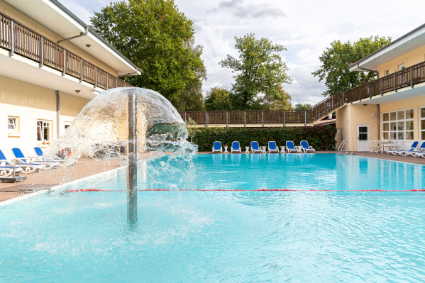 Wasserfontäne im Poolbereich mit Blick auf das Hauptgebäude bei Baltic Freizeit.