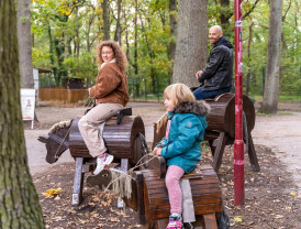 Zwei Kinder reiten auf Holzpferden auf dem Campingplatz von Baltic Freizeit.