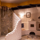 Detailansicht eines Entspannungsbereichs im 'Baltic Spa' des Campingplatzes mit Steinmauern, weißem Ornamentputz und traditionellem Ofen.