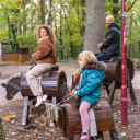 Zwei Kinder reiten auf Holzpferden auf dem Campingplatz von Baltic Freizeit.