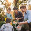 Familie sammelt Ostereier draußen im Sonnenschein