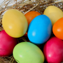 Bunte Ostereier in Rot, Gelb, Blau, Grün und Orange im Stroh